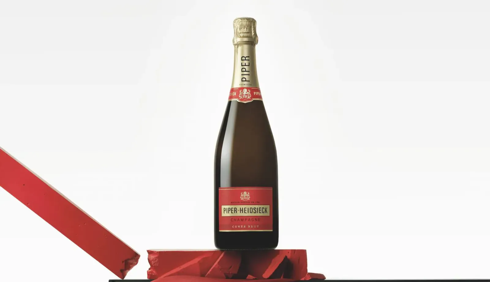 Veuve Clicquot champagne bottle on torn red gift wrapping ribbon, luxury Christmas gift.