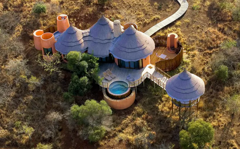 Aerial view of Thanda Safari luxury thatched villas with pool and deck in African savanna