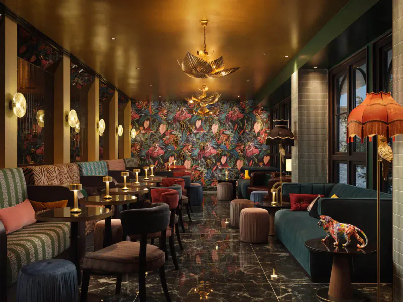 Luxurious hotel lounge with gold ceiling, floral walls, ornate chandelier, plush velvet seating, marble floor, and leopard sculpture.