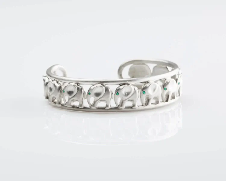 Silver open cuff bracelet with intricate elephant motifs and turquoise accents