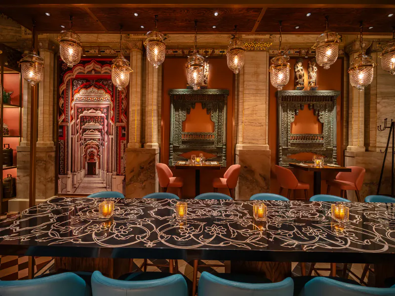 Masala Zone Piccadilly Circus grand brasserie interior with ornate Indian arches, teal chairs, and candlelit black table.