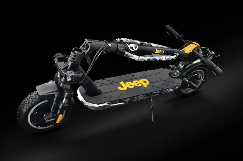 Black Jeep-branded electric scooter folded, rugged design with yellow Jeep logos on black background.