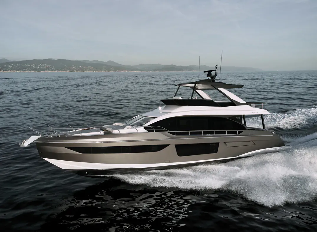 Sleek gray Azimut luxury yacht speeding on sea with coastal hills in background