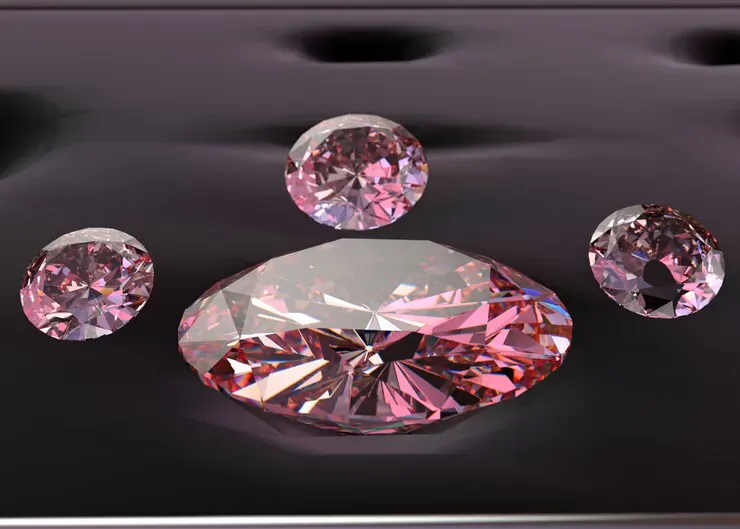 Four pink faceted crystals on black velvet, central large diamond-shaped crystal highlighted