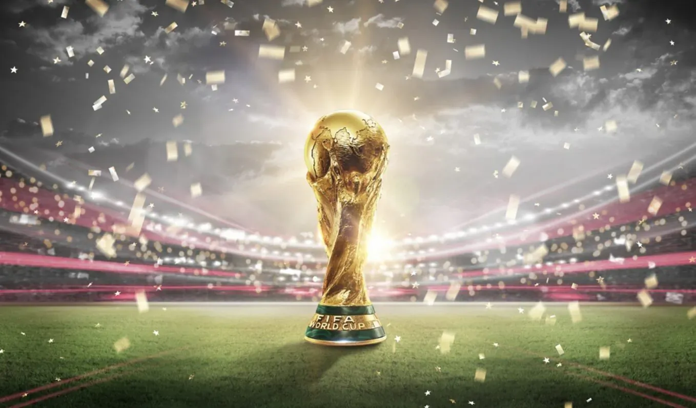 Golden FIFA World Cup trophy glowing on stadium field amid confetti and lights