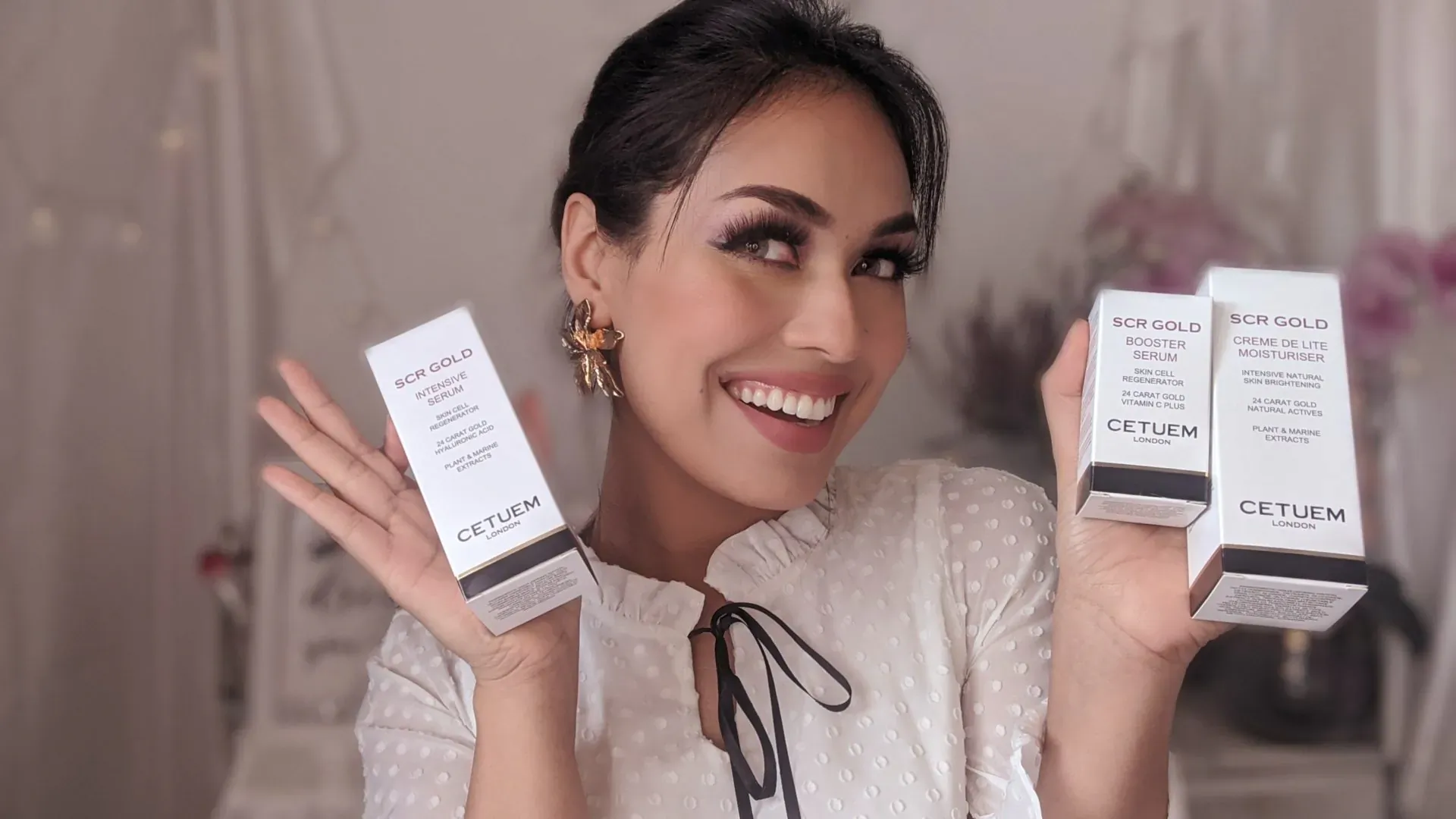 Smiling woman holding Cetuem SCR GOLD skincare boxes, white packaging with gold accents, in elegant setting