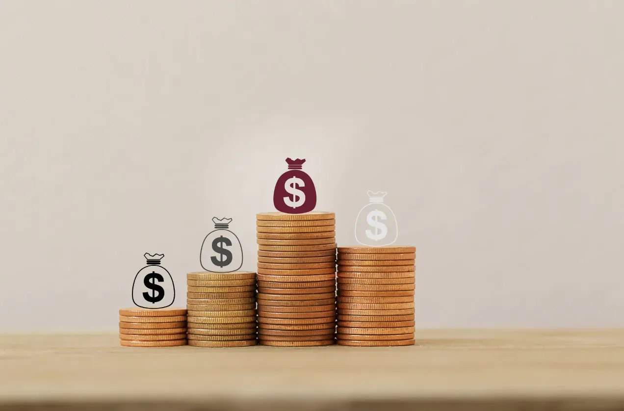 Stacks of gold coins topped with money bags marked 'S' on a wooden surface, symbolizing secure payments.