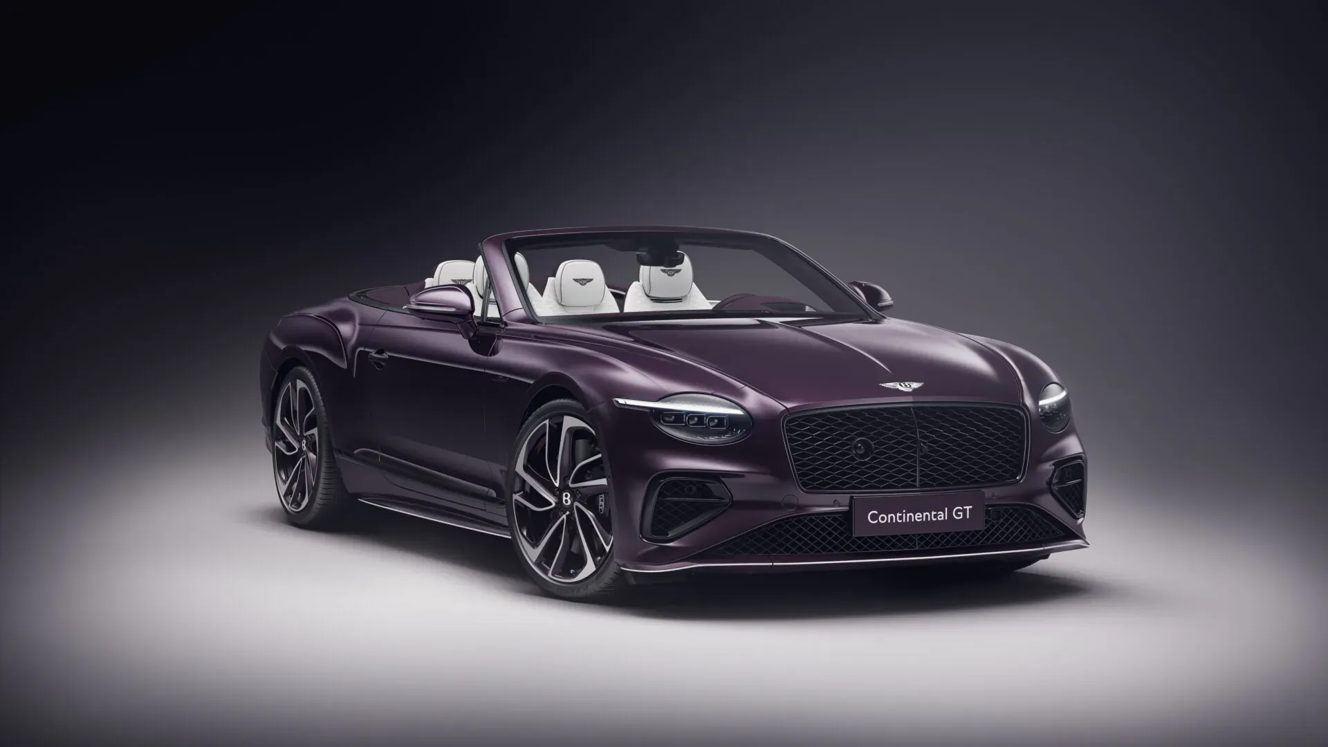 Purple Bentley Continental GTC Speed convertible with white seats, front view on dark background