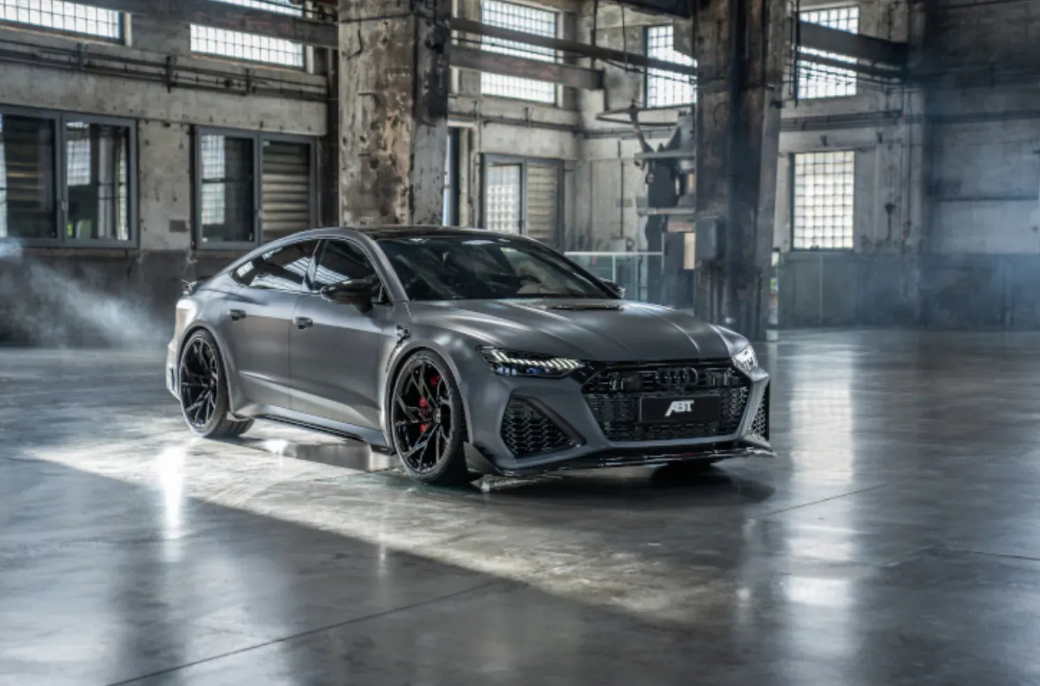 ABT RS7 Legacy Edition Audi in industrial warehouse with dramatic lighting and fog.