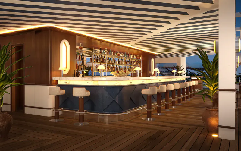Elegant outdoor bar at Le Ciro's, Hotel Barrière Le Majestic Cannes, with blue stools, wood counter, and potted palms at dusk.