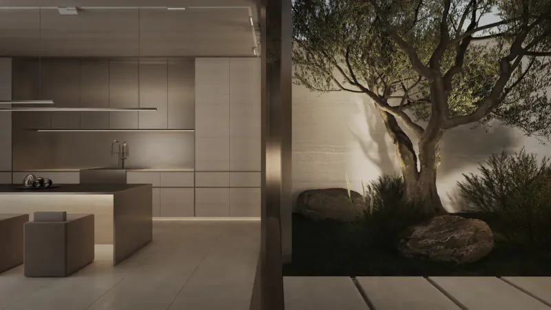 Modern minimalist kitchen with sleek white cabinets and island, adjacent to serene garden courtyard featuring olive tree and rocks.